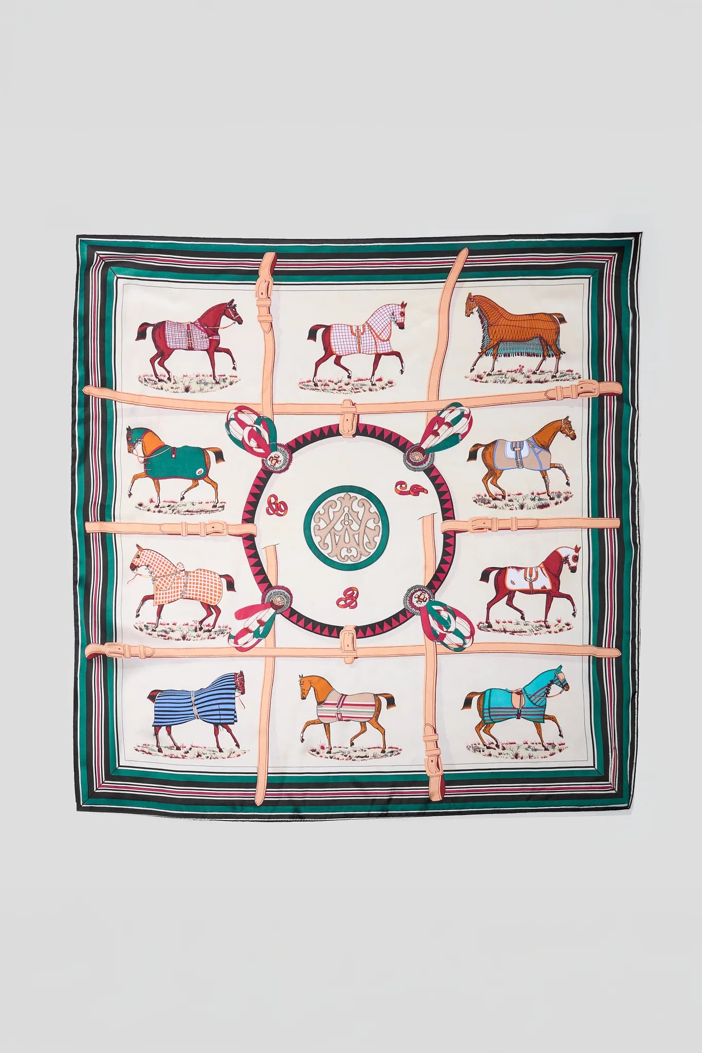 A square silk scarf featuring a classic Persephone-inspired design with nine illustrated horses in various colors, arranged around a central medallion. The design is framed by a striped border in shades of green, pink, and white, and is overlaid with four diagonal pink straps.