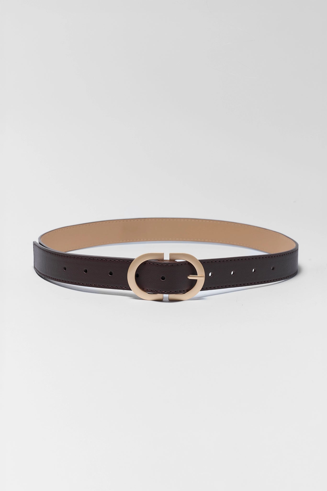 A slim dark brown leather belt with a gold-tone oval buckle, displayed horizontally on a light gray background.