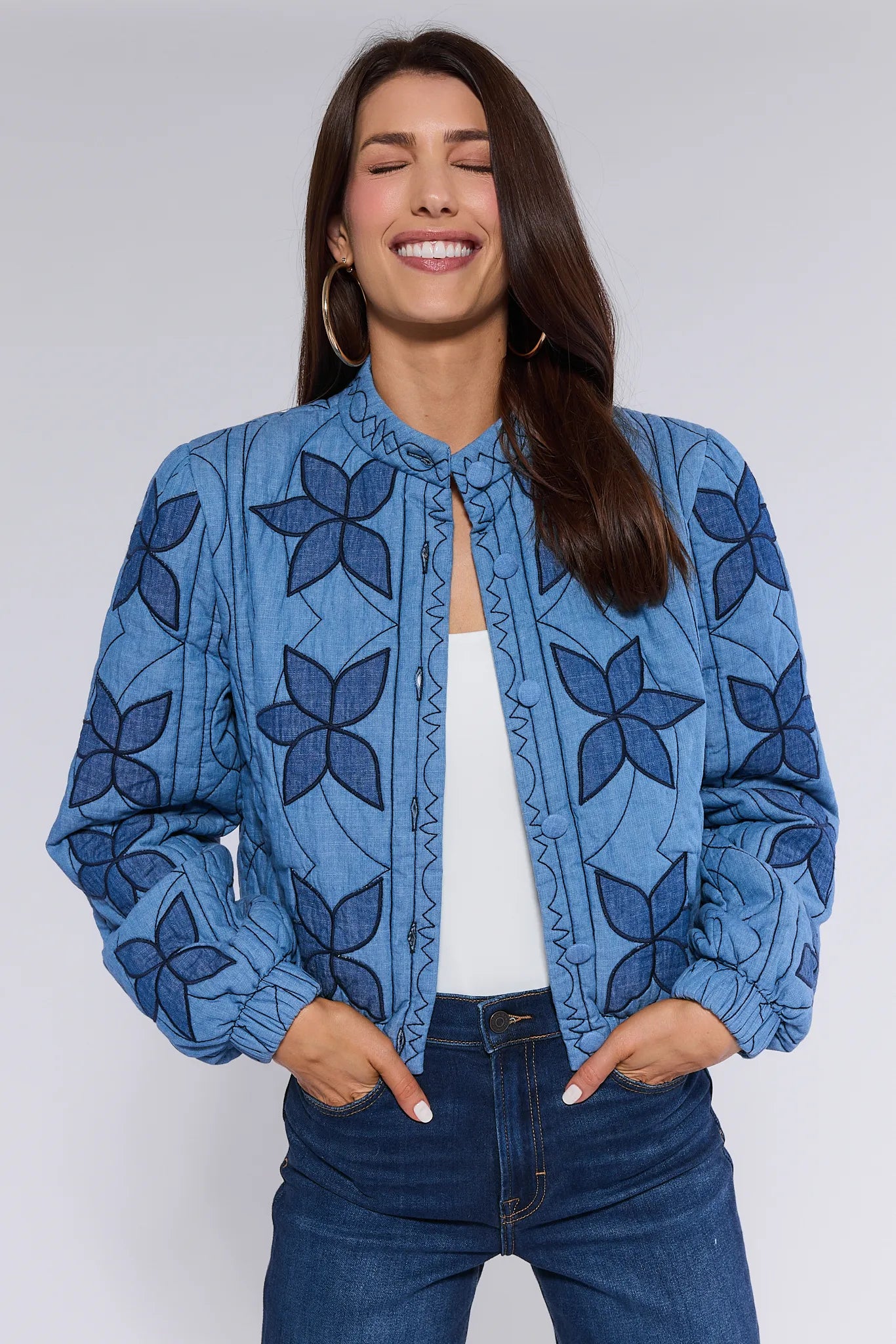 Woman wearing a blue floral patterned Krista Jacket against a white background