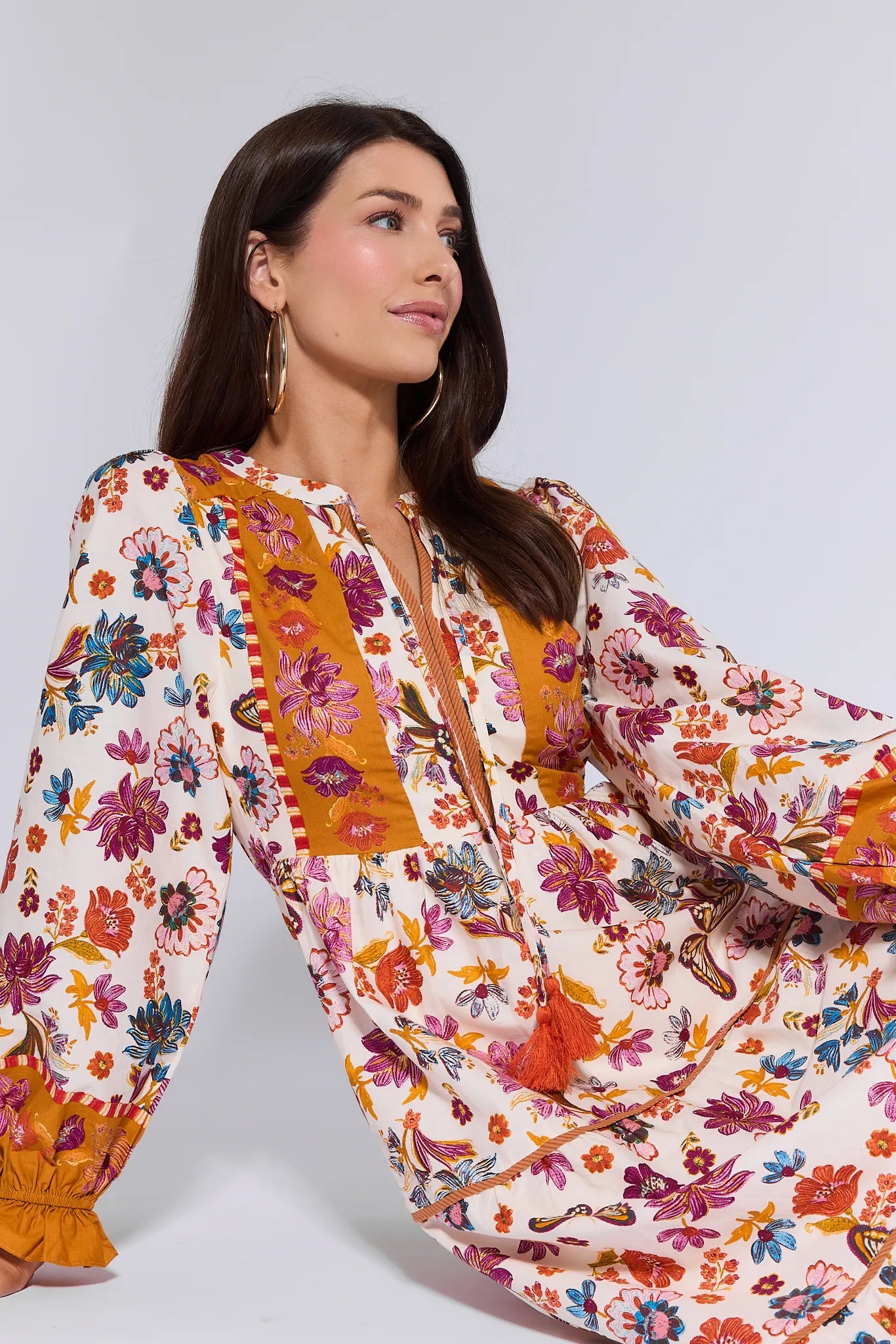 Woman wearing a colorful floral Shiloh Dress against a white background
