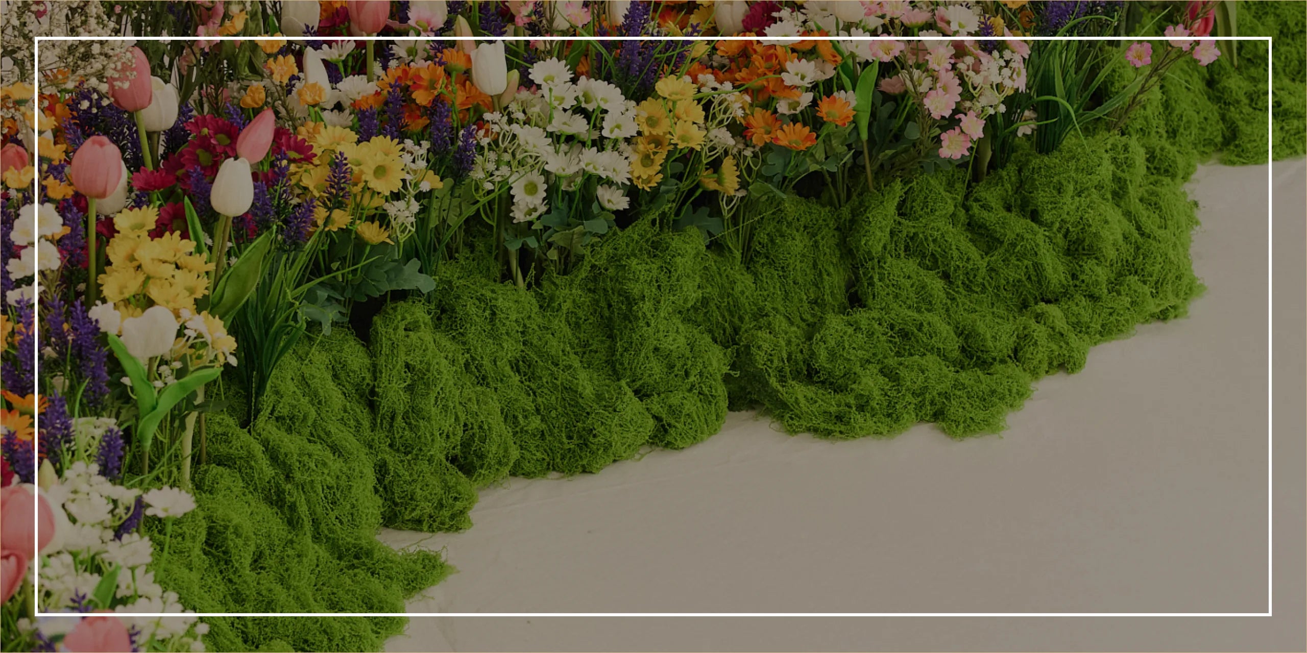 Floral border with a variety of flowers and greenery on a plain background