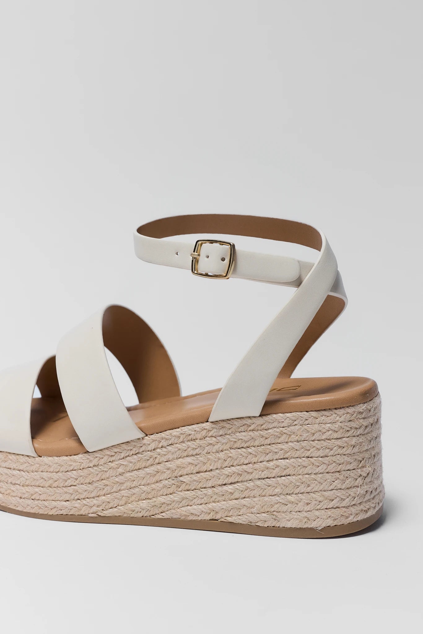 close up White sandal with brown sole on a light gray background