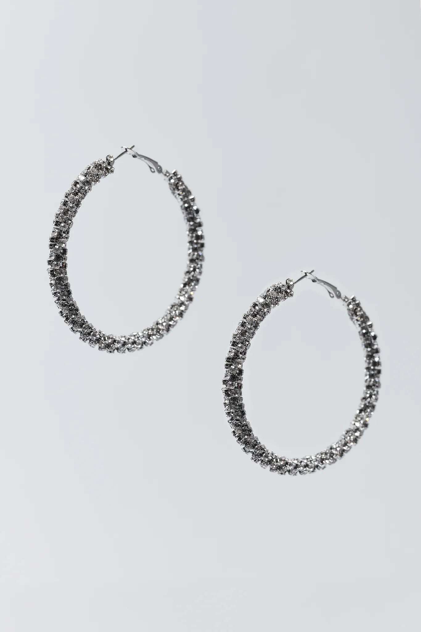Pair of silver hoop earrings on a light gray background