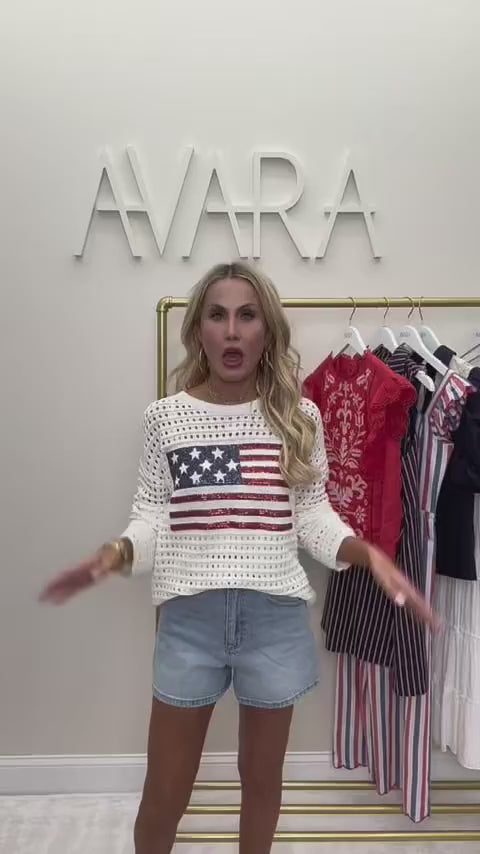 woman wearing starla flag sweater with rack in background