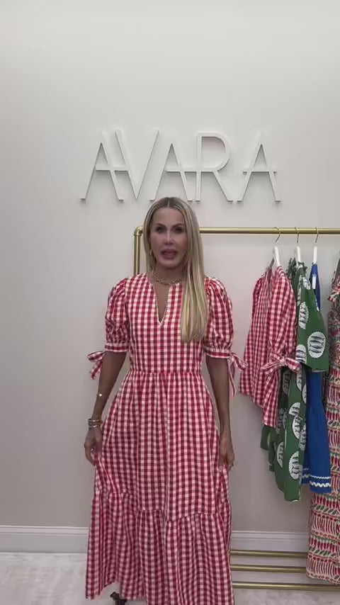 Woman wearing Hazel Gingham Dress with AVARA letters in background
