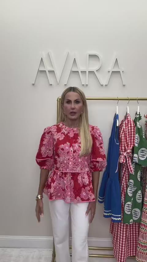 Woman wearing abigail red top with AVARA letters in background