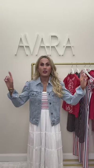 woman wearing roxanna denim jacket with rack of clothing behind her