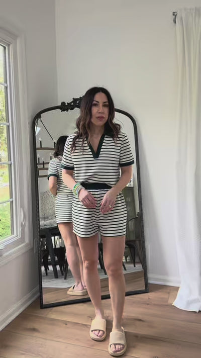 woman wearing green striped set with mirror in background
