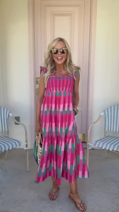 woman in avery midi dress wearing sunglasses standing outside
