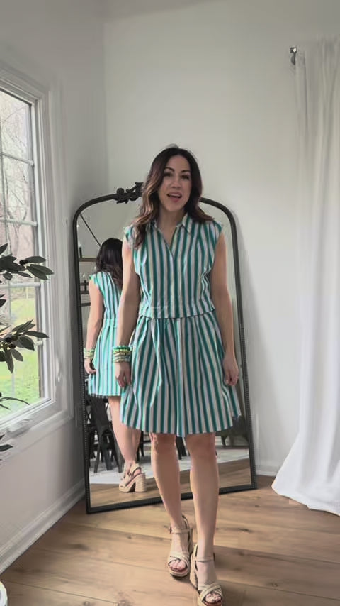 woman wearing green stripe evie dress with mirror in background