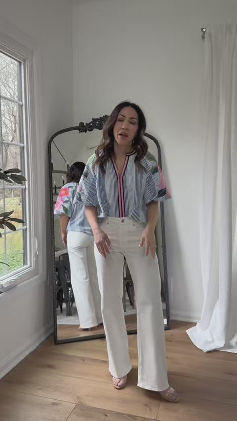 Woman wearing Coleen Top with white jeans and mirror in background