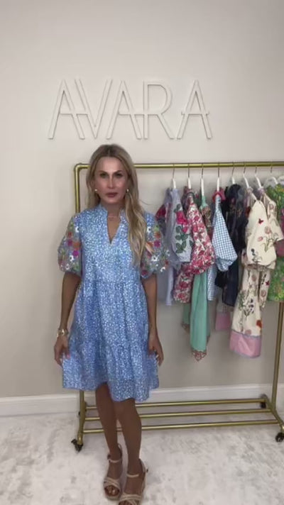 woman wearing blue short dress with embroidered flowers on sleeve